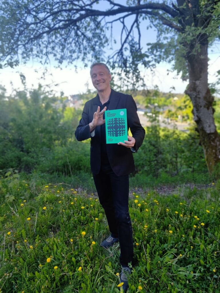 Holger Holland mit dem Buch „Wir schaffen Zukunft“, Porträt