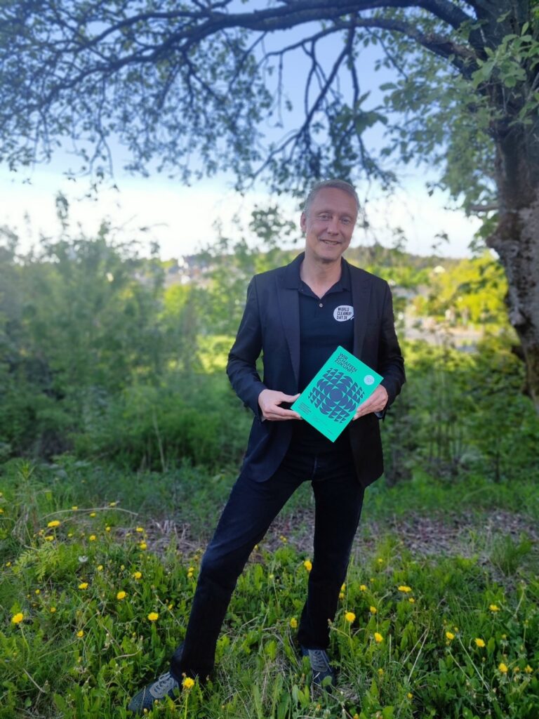 Holger Holland mit dem Buch „Wir schaffen Zukunft“ im Sonnenlicht